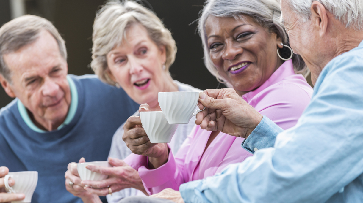 Multi-ethnic group of four seniors sitting outdoors