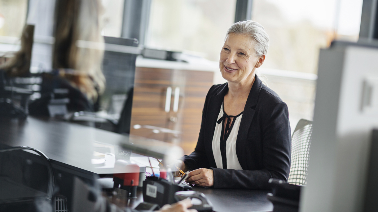 Senior Businesswoman talking with employee