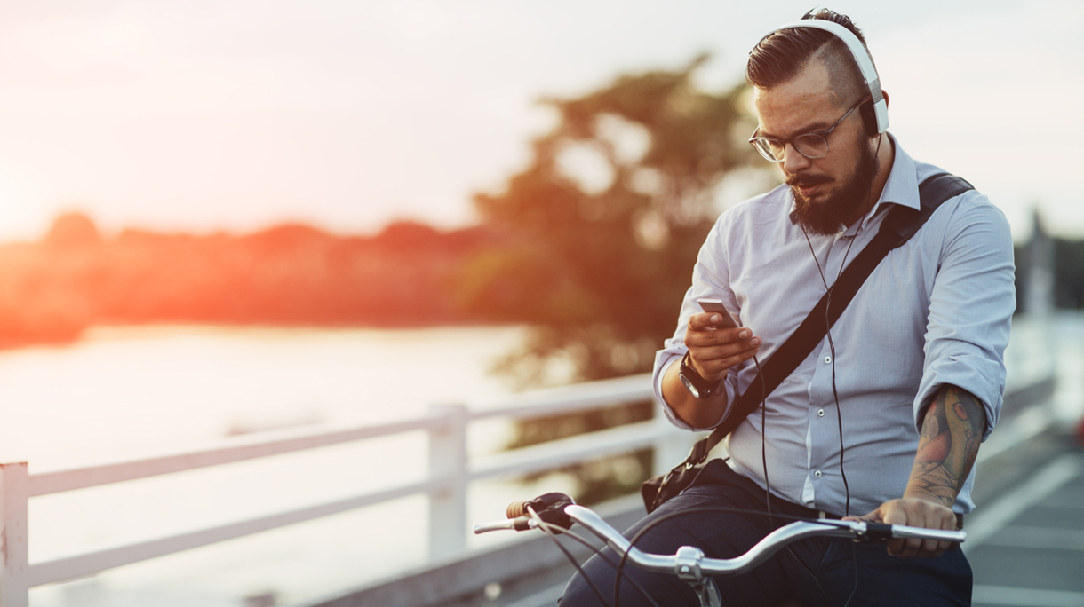 Businessman Sitting On Bicycle And Using Smartphone Outdoors.