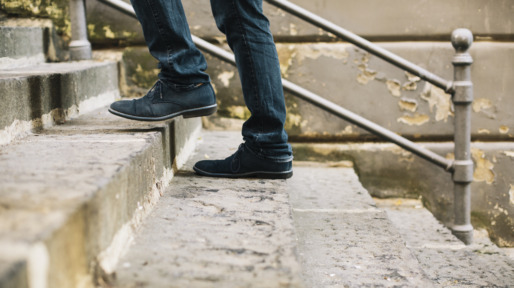 Close-up of man’s shoes walking upstairs
