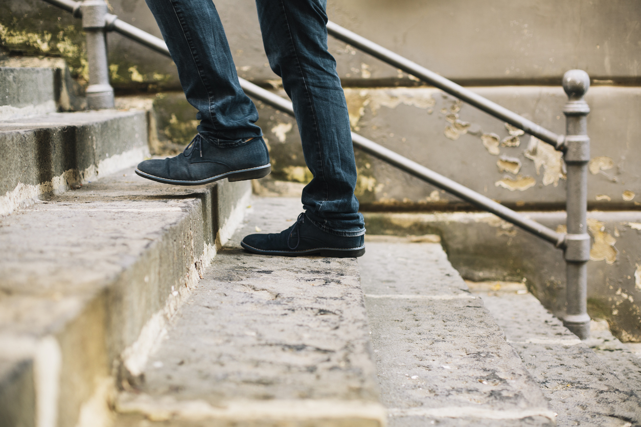 Close-up of man’s shoes walking upstairs