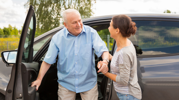 Caregiver helping senior out of the car
