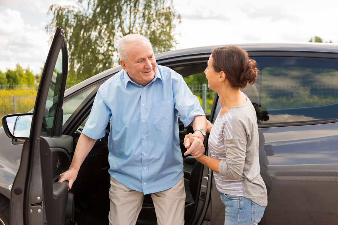 Caregiver helping senior out of the car