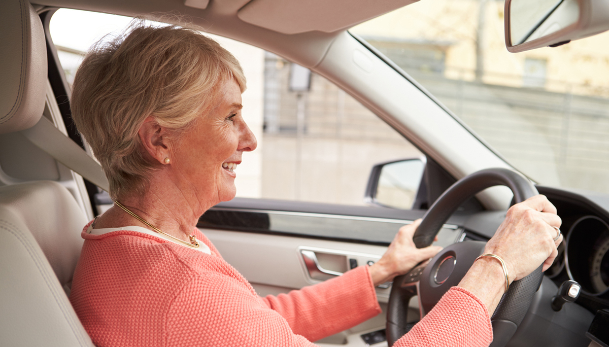 In car view of senior female driver at the wheel of