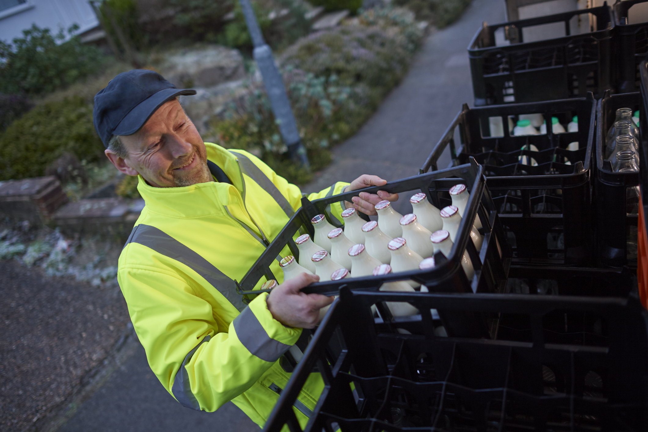 Milkman unloading his milk float in early morning