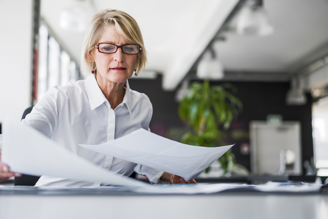 Businesswoman examining documents at desk