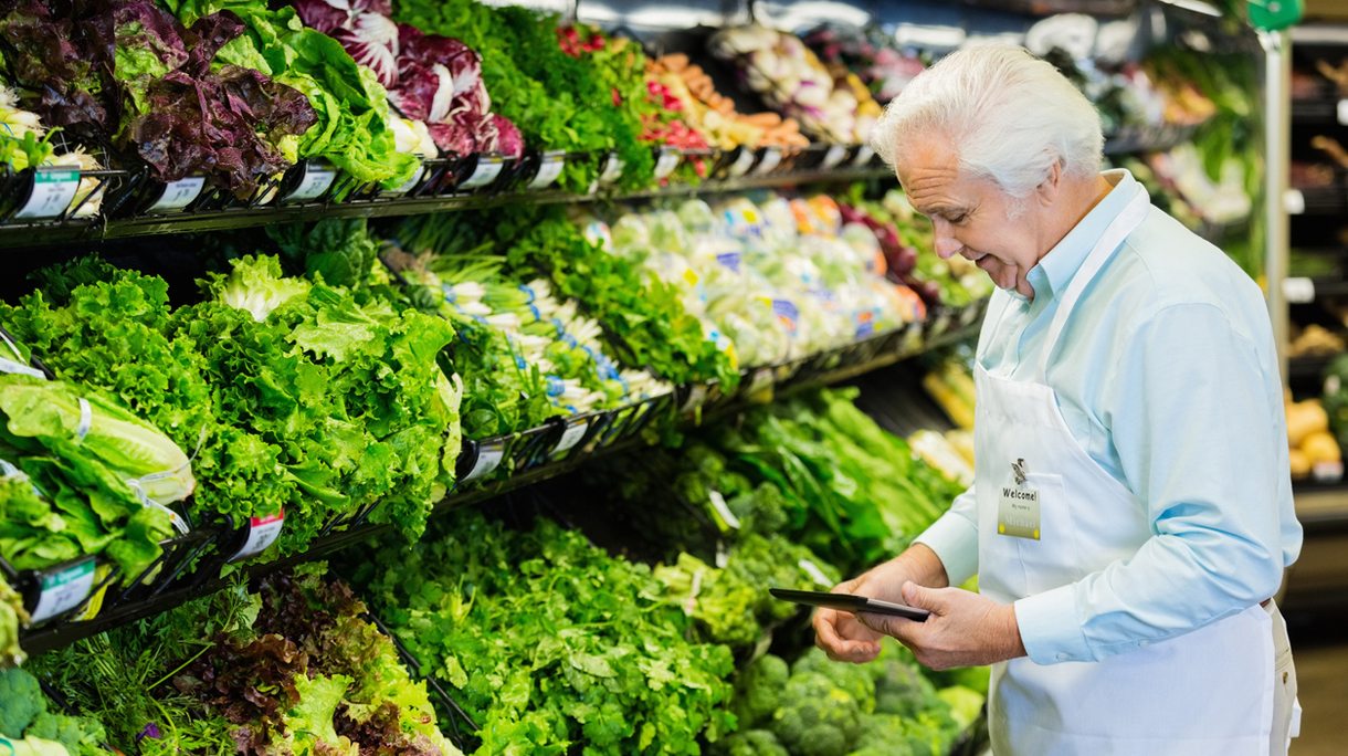 Senior grocery store manager taking inventory with digital tablet