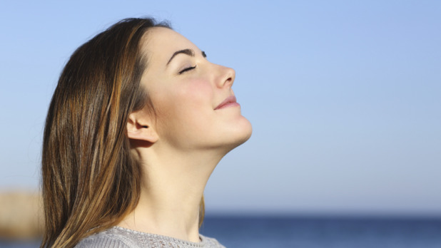 Woman portrait breathing deep fresh air on the beach