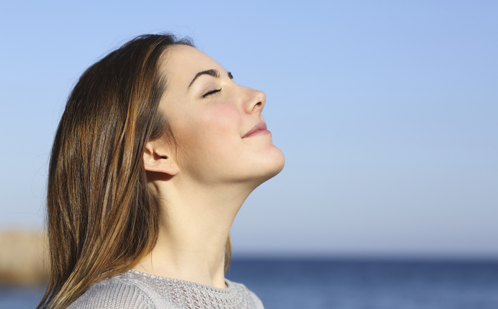 Woman portrait breathing deep fresh air on the beach