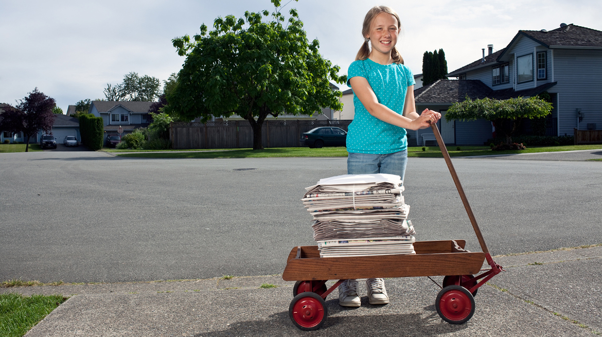 Girl delivering newspapers in her neighborhood.