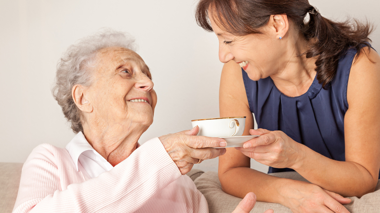 Senior woman and home caregiver having fun