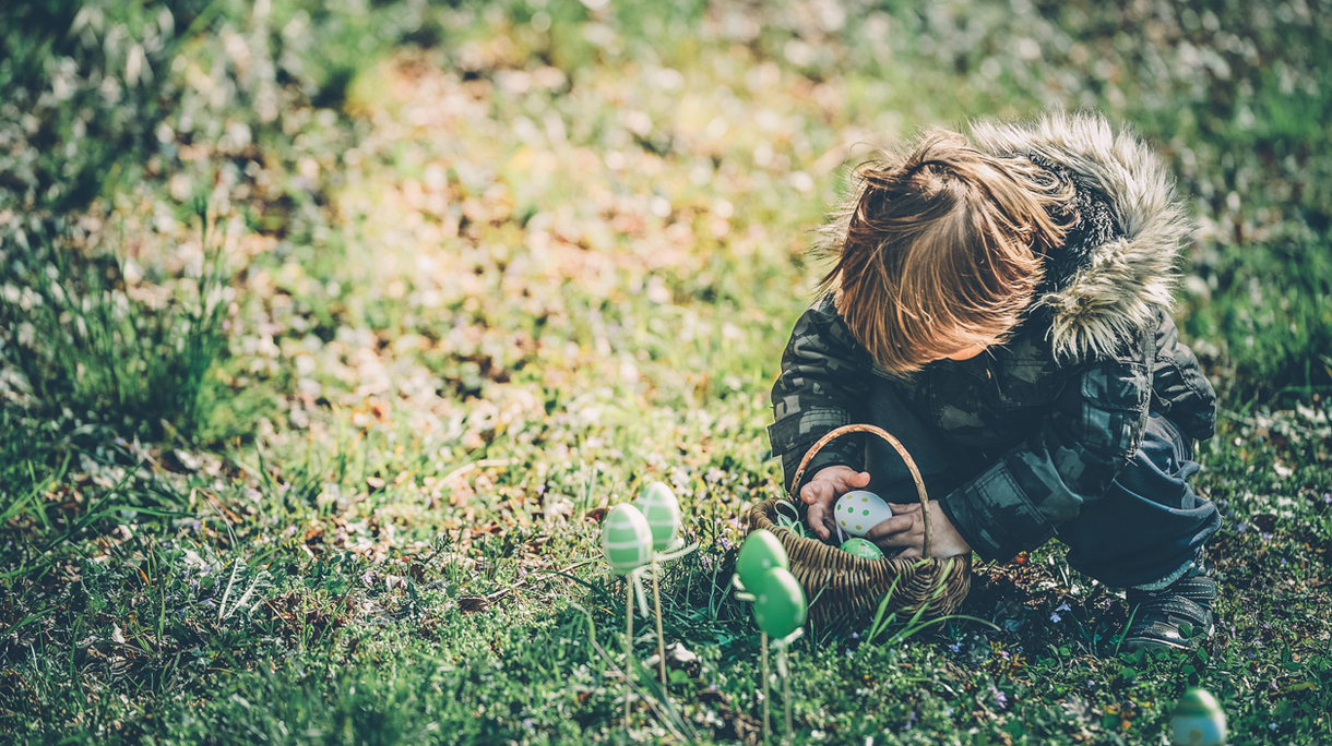 Little Boy Playing with Easter Eggs Outdoors