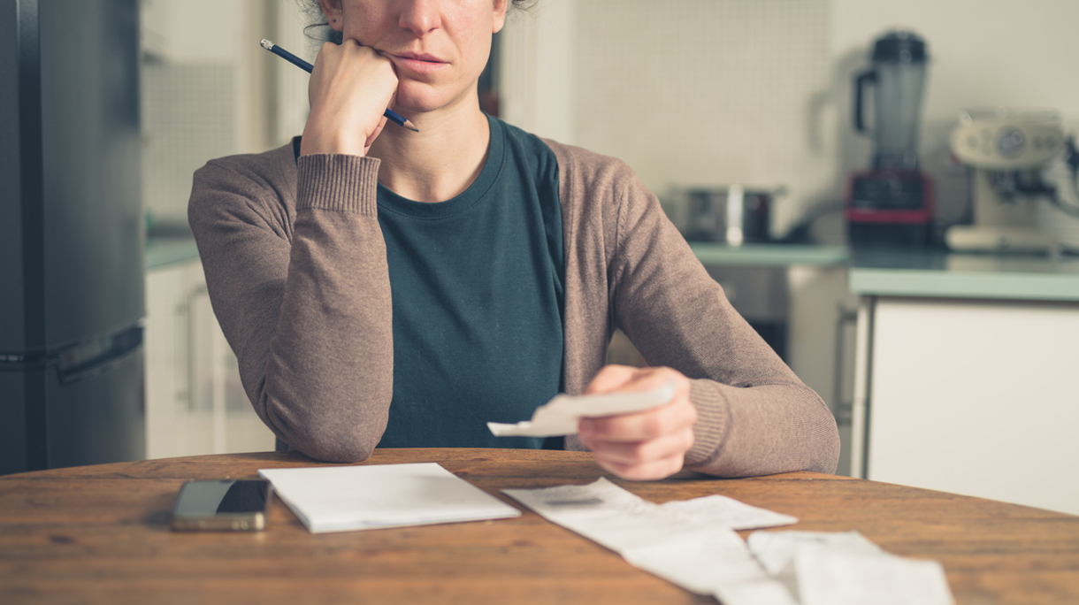Woman looking at receipts at home