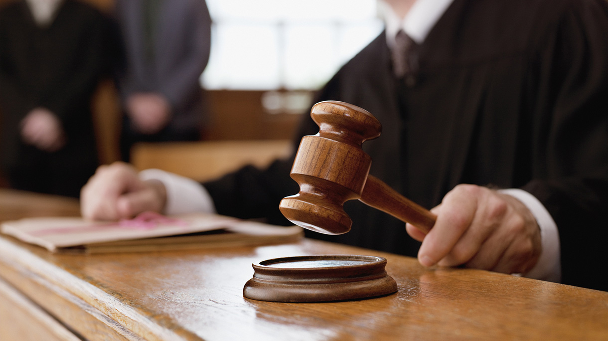 Judge holding gavel in courtroom