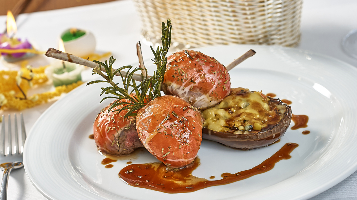 Image of lamb chops on a bed of vegetables Eggplant stuffed with vegetables