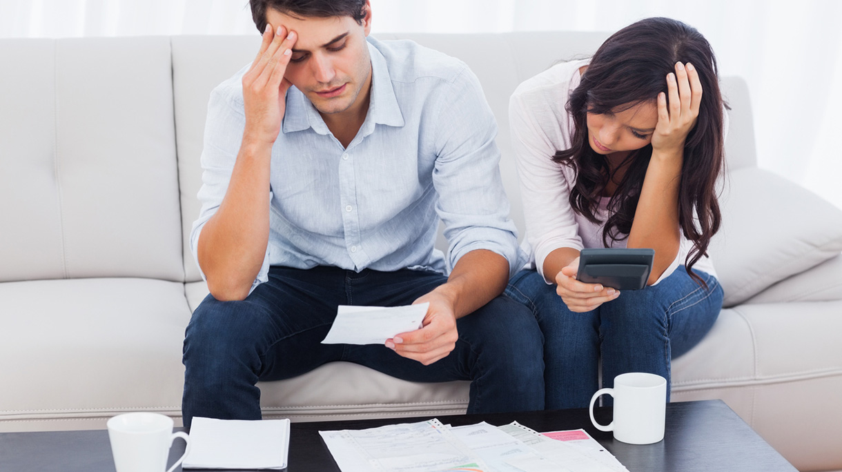 Couple holding their heads and are doing accounts