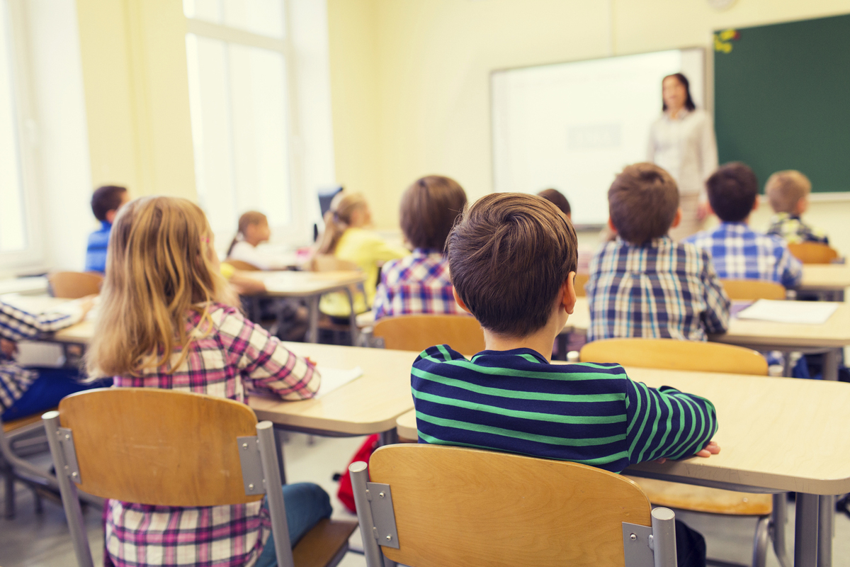 group of school kids and teacher in classroom
