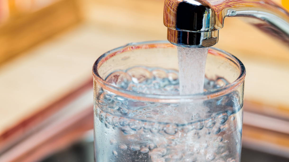 Filling up a glass with drinking water from kitchen tap