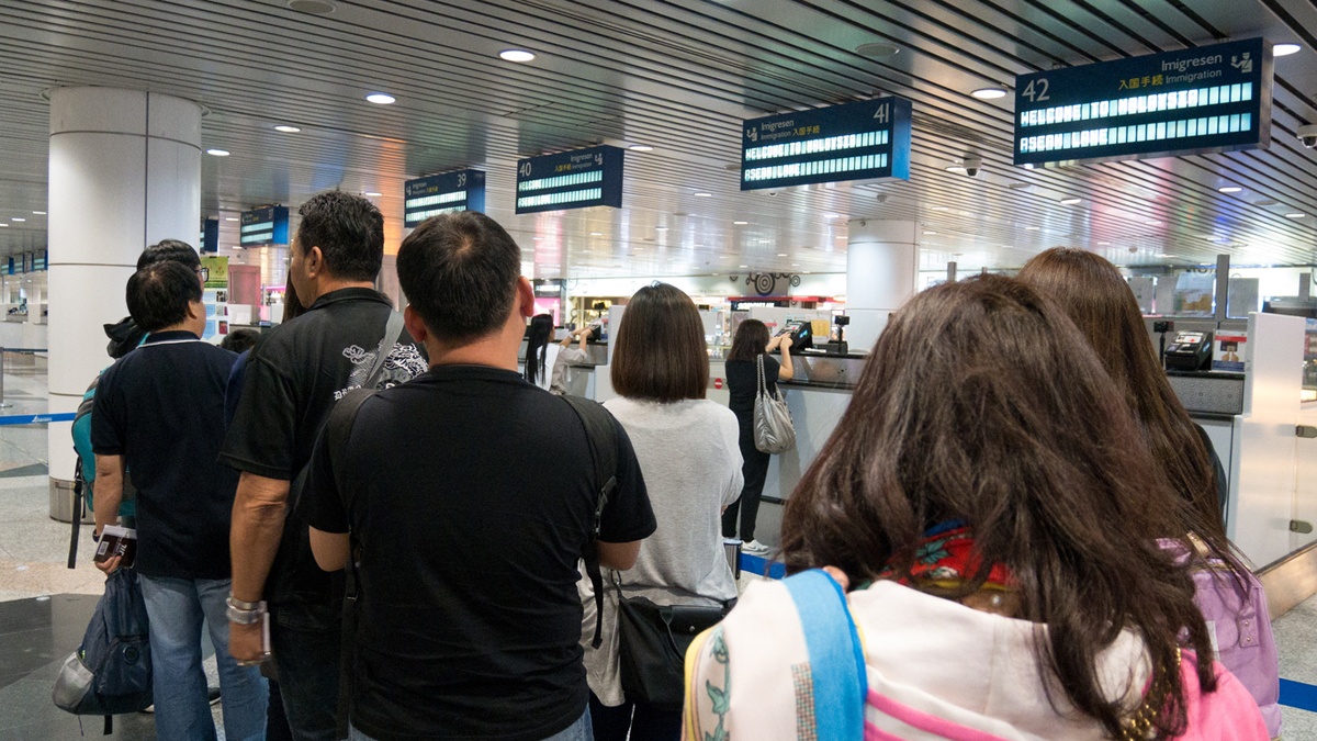 MALAYSIA – MAR 21, 2017: Group of travelers enter immigration control at Kuala Lumpur International Airport (KLIA) in Malaysia.
