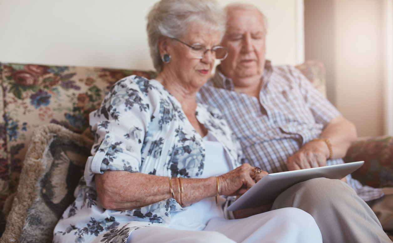 Senior couple using digital tablet at home