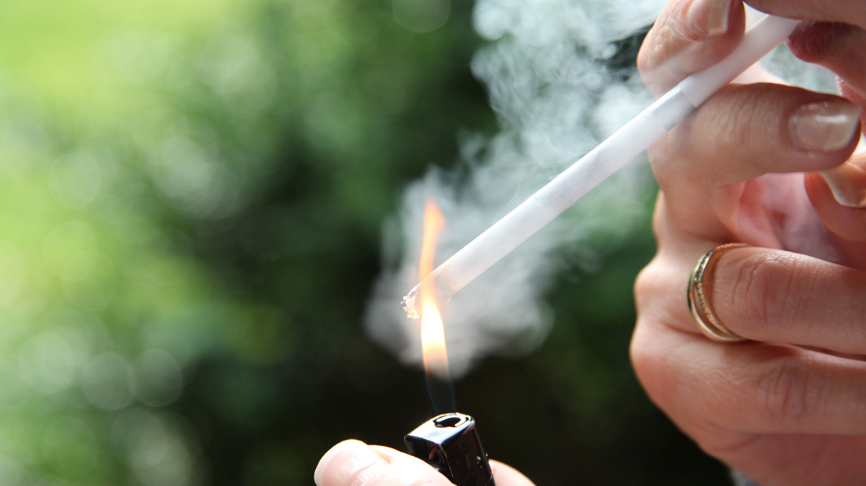 Smoker with lighter cigarette smoking outdoors