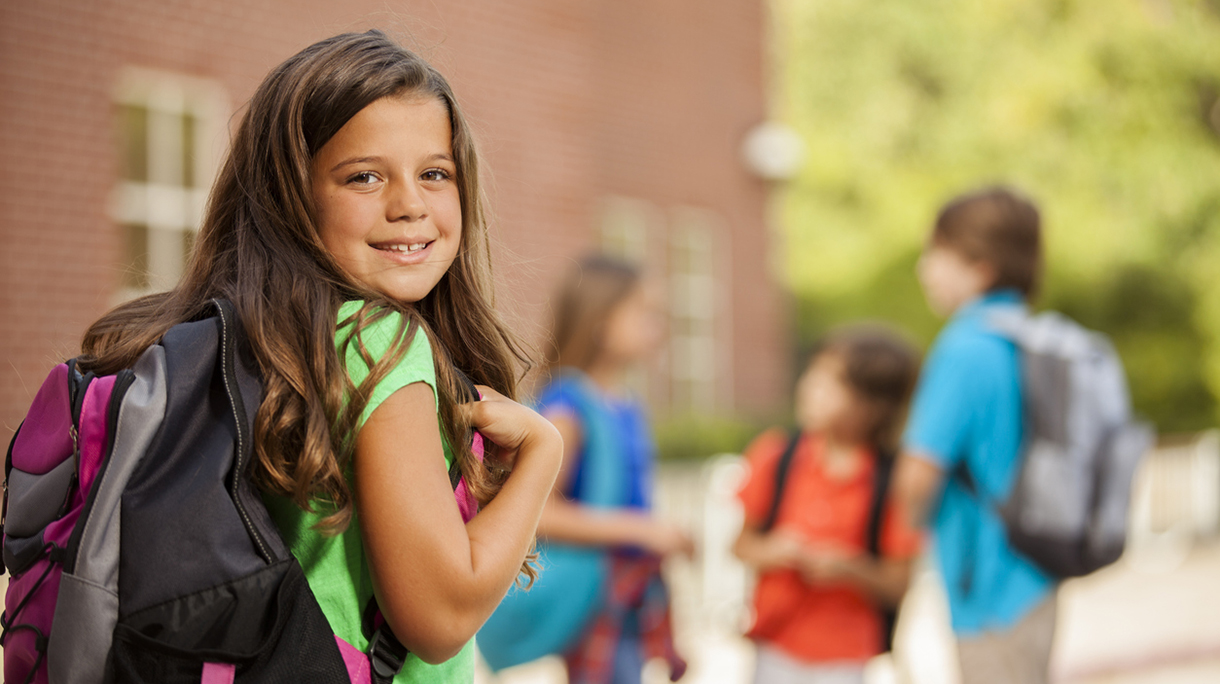 Back to School:  Elementary-age children, girl on school campus.