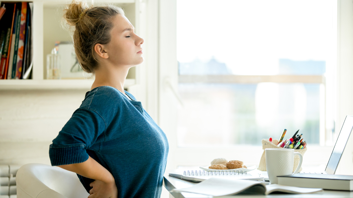 Portrait of an attractive woman at the table backache pose