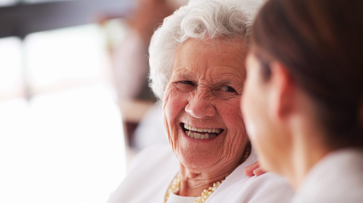 Smiling elderly woman and female nurse