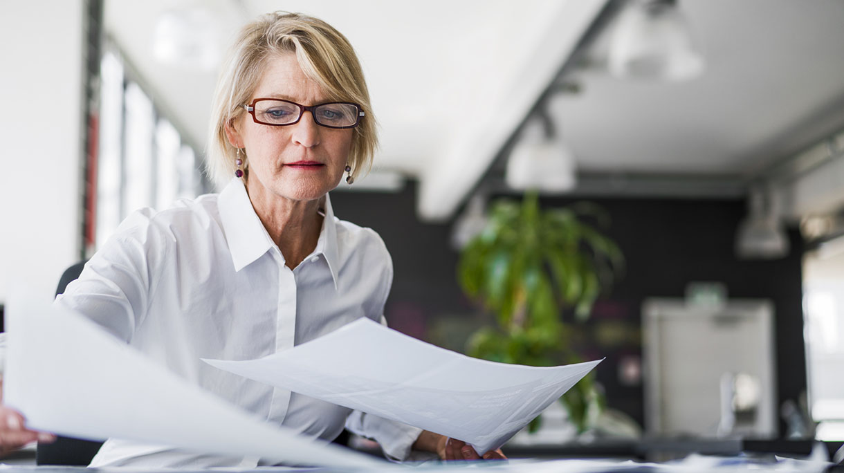 Businesswoman examining documents at desk