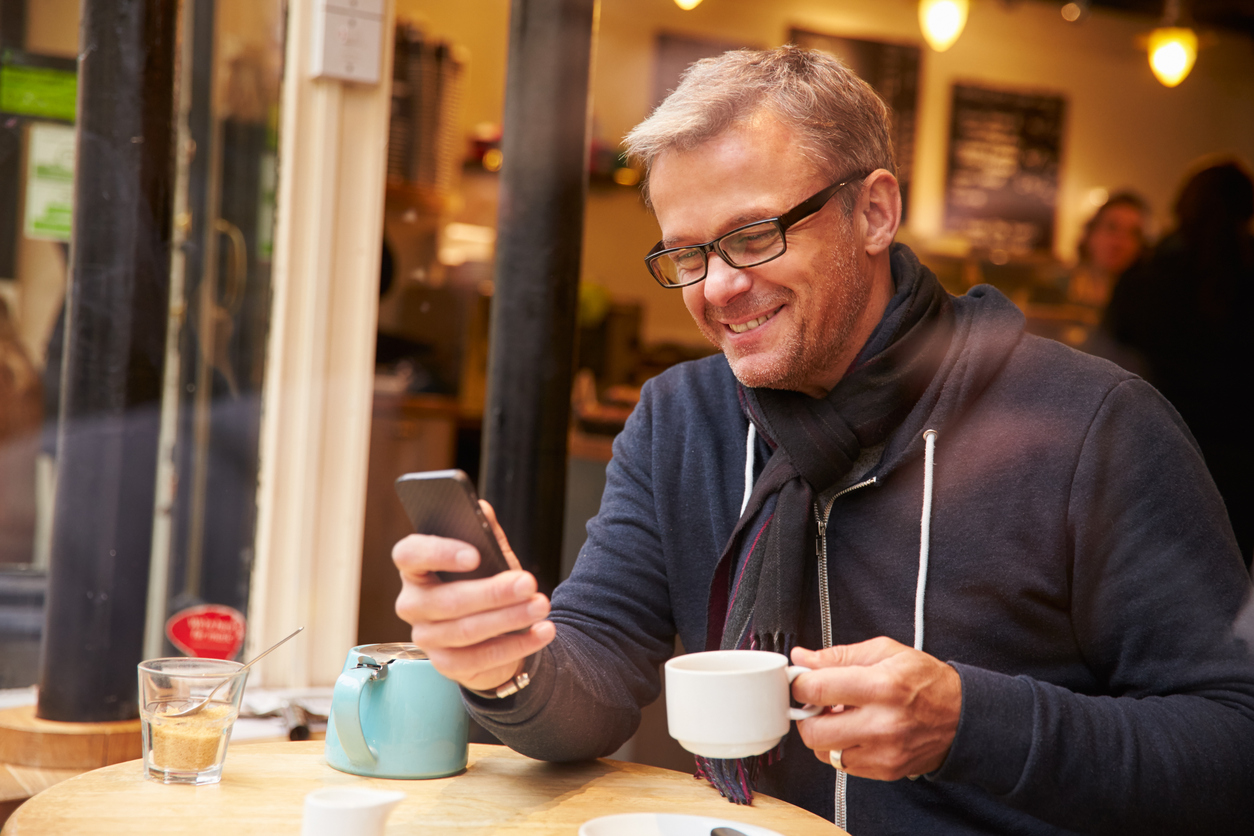 Man Viewed Through Window Of Caf Using Mobile Phone