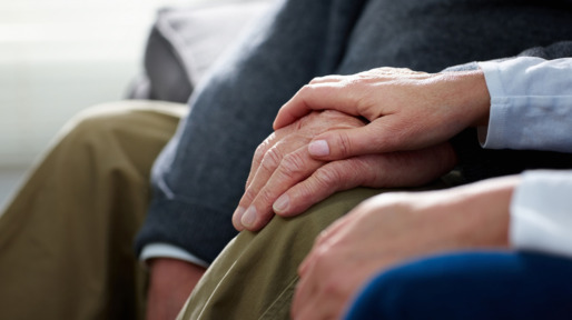 Nurse holding hand of senior male patient