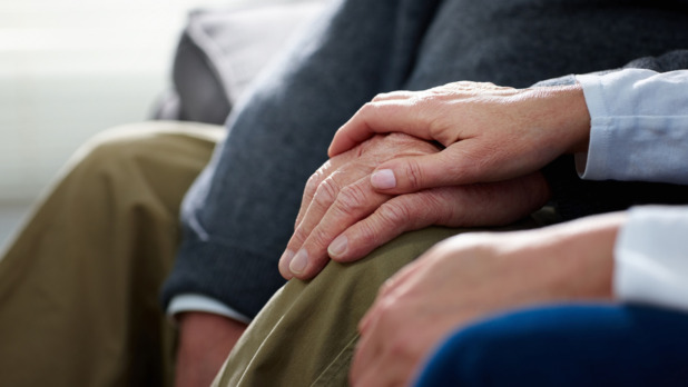Nurse holding hand of senior male patient