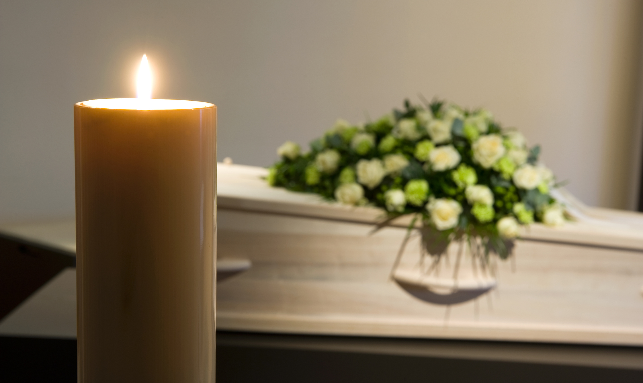 Burning candle in front of coffin