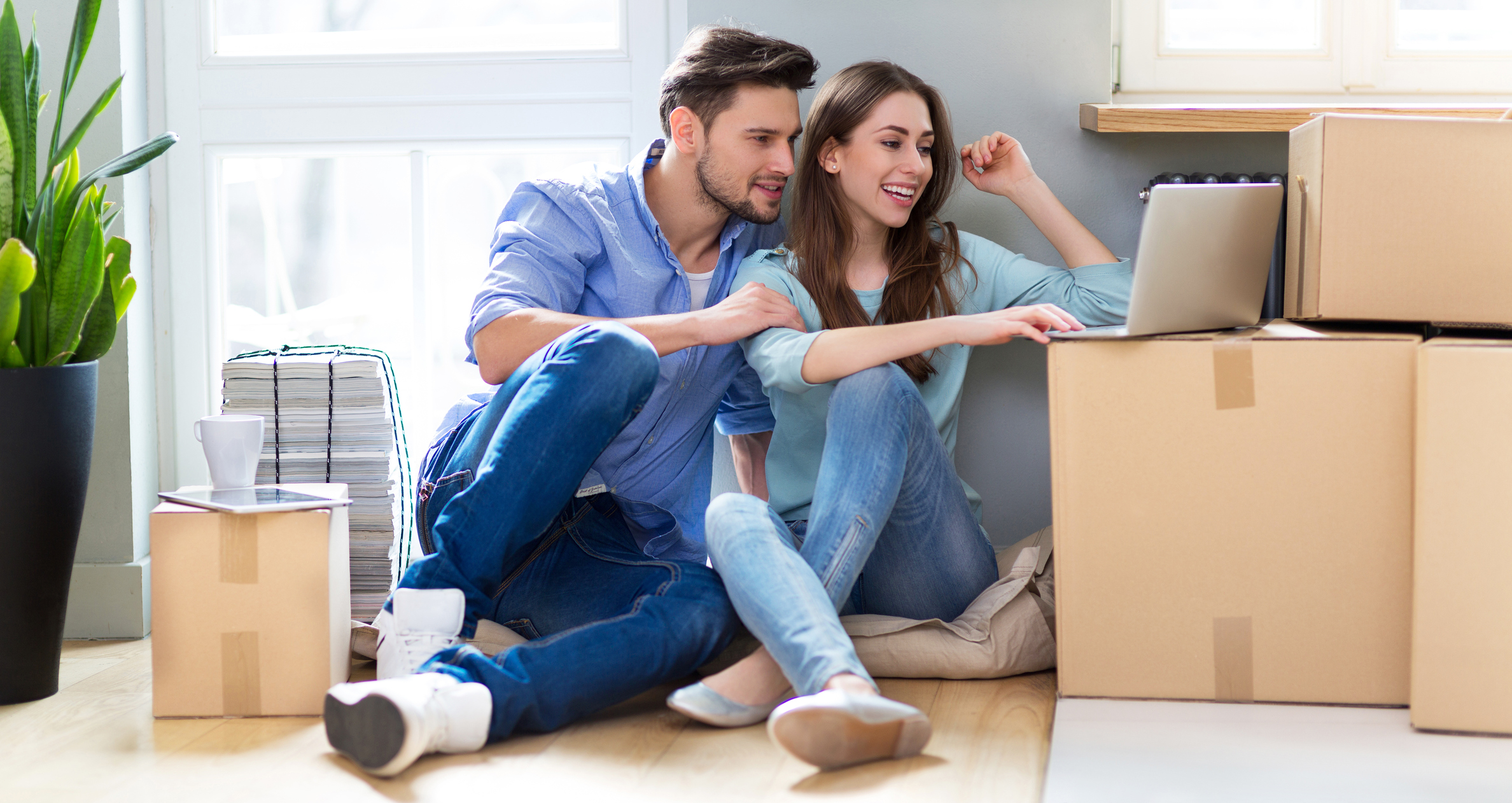 Couple on floor next to moving boxes