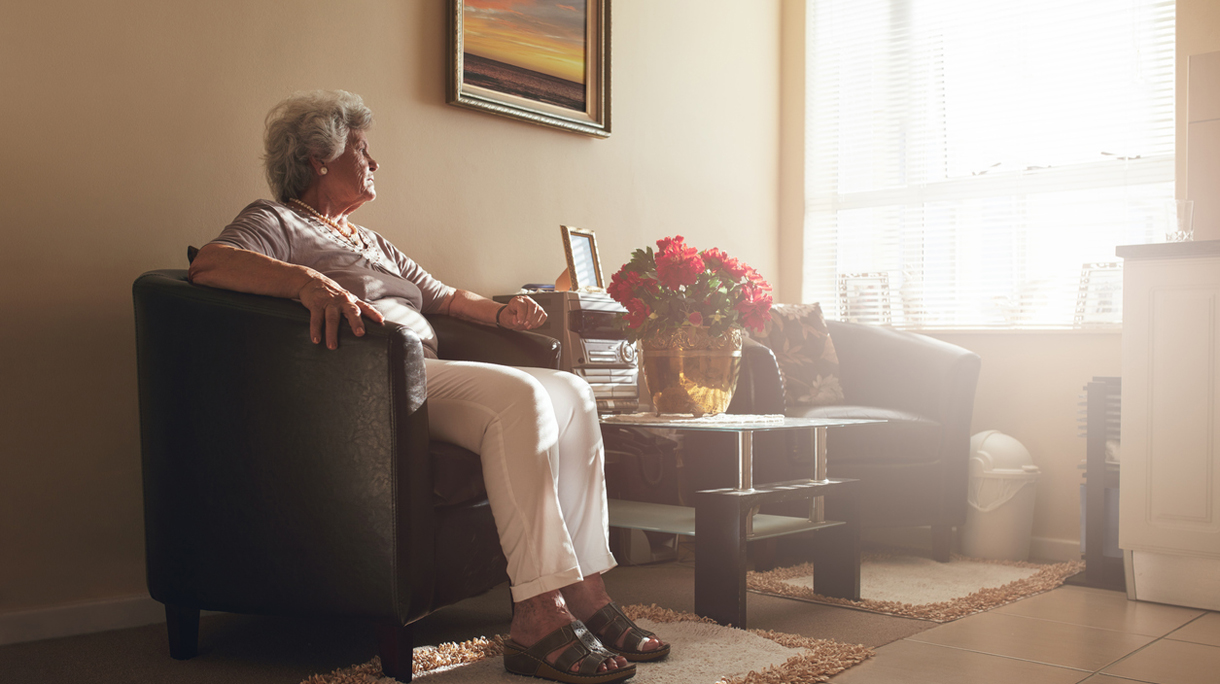 Senior woman sitting alone on a chair at home