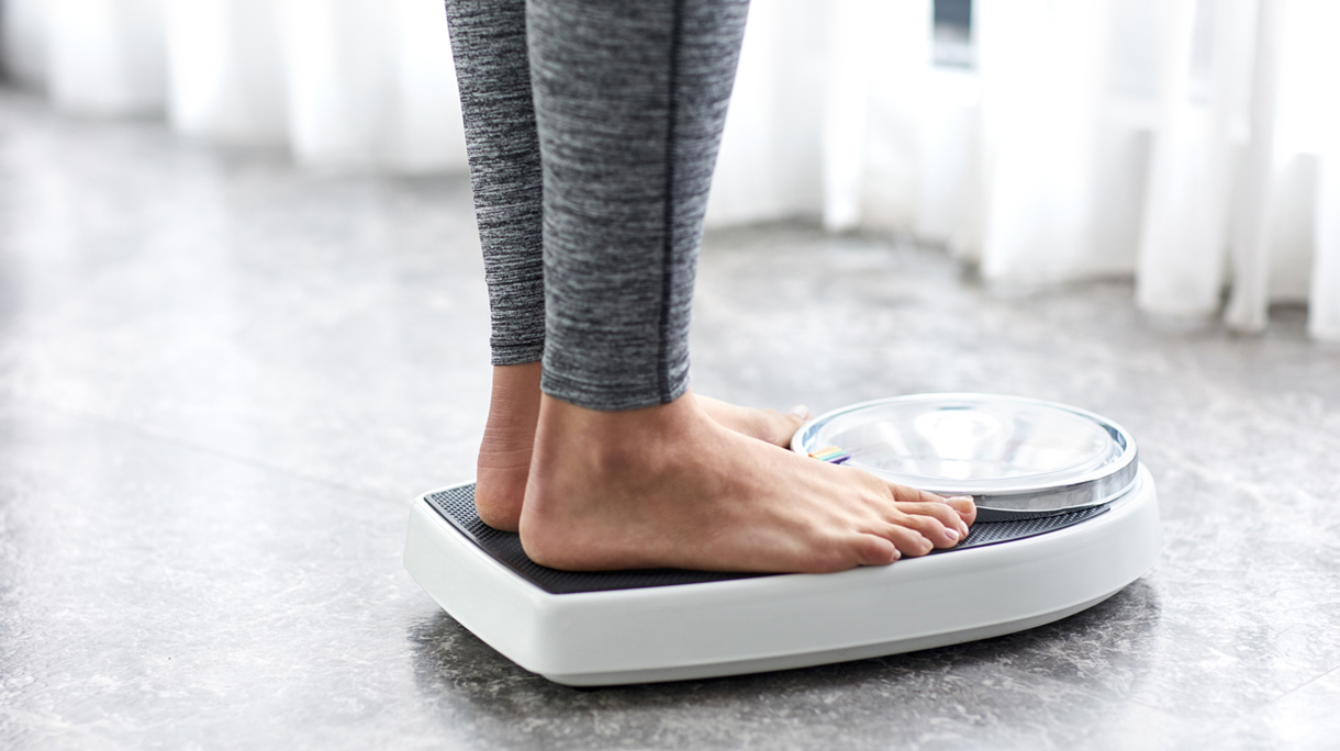 Young healthy girl on home scales