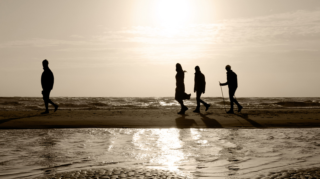 Family walking on the beach, sunset