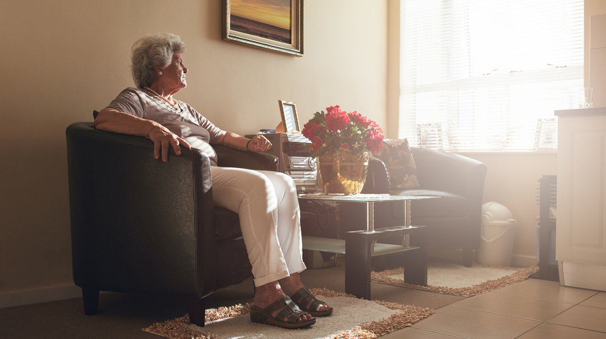 Senior woman sitting alone on a chair at home