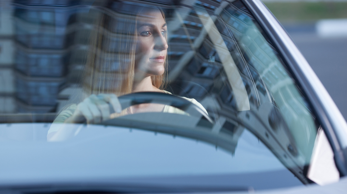 young adult blonde woman driving a car