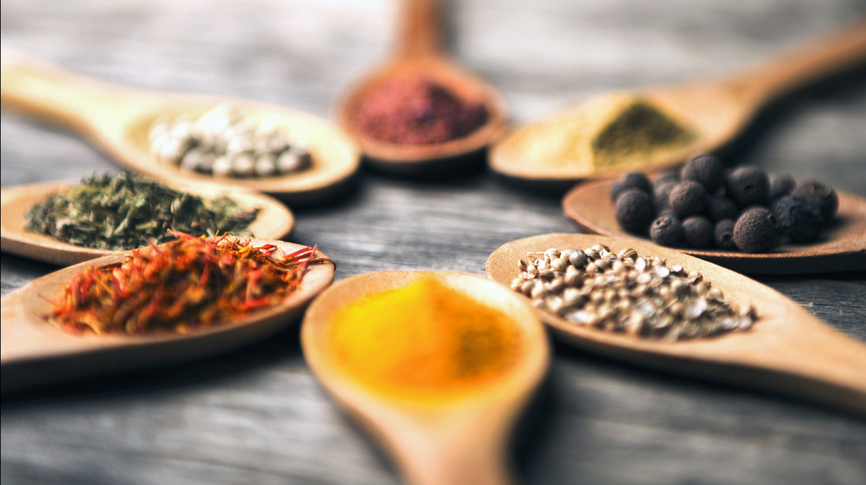 Spices in spoons arranged in circle