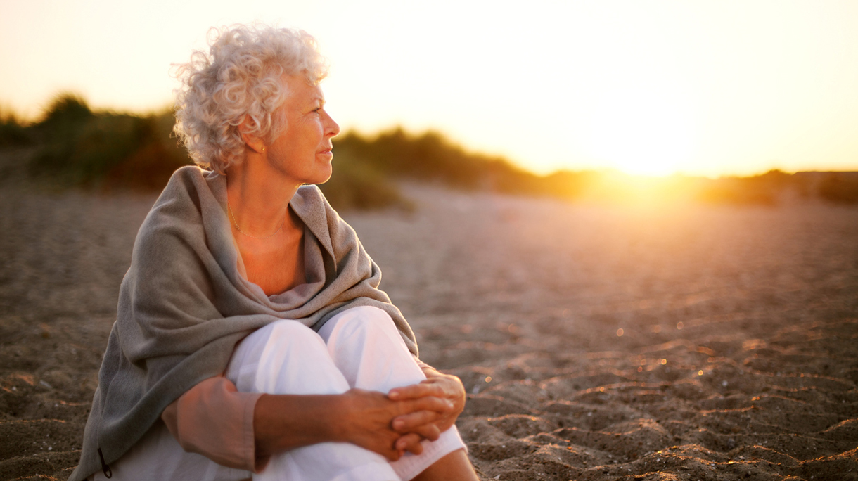 Mature woman on beach looking into horizon