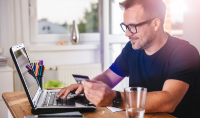Man paying with credit card on laptop