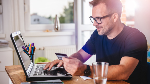Man paying with credit card on laptop