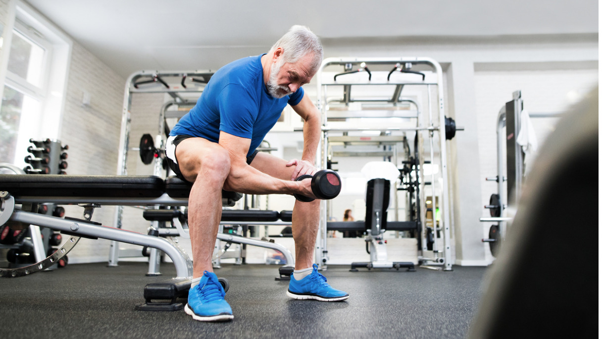 senior-man-in-gym-working-out-with-weights-picture-id638995528
