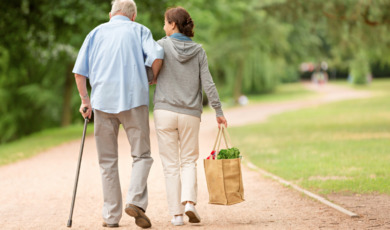 caregiver-woman-helping-senior-man-with-shopping-picture-id587506108