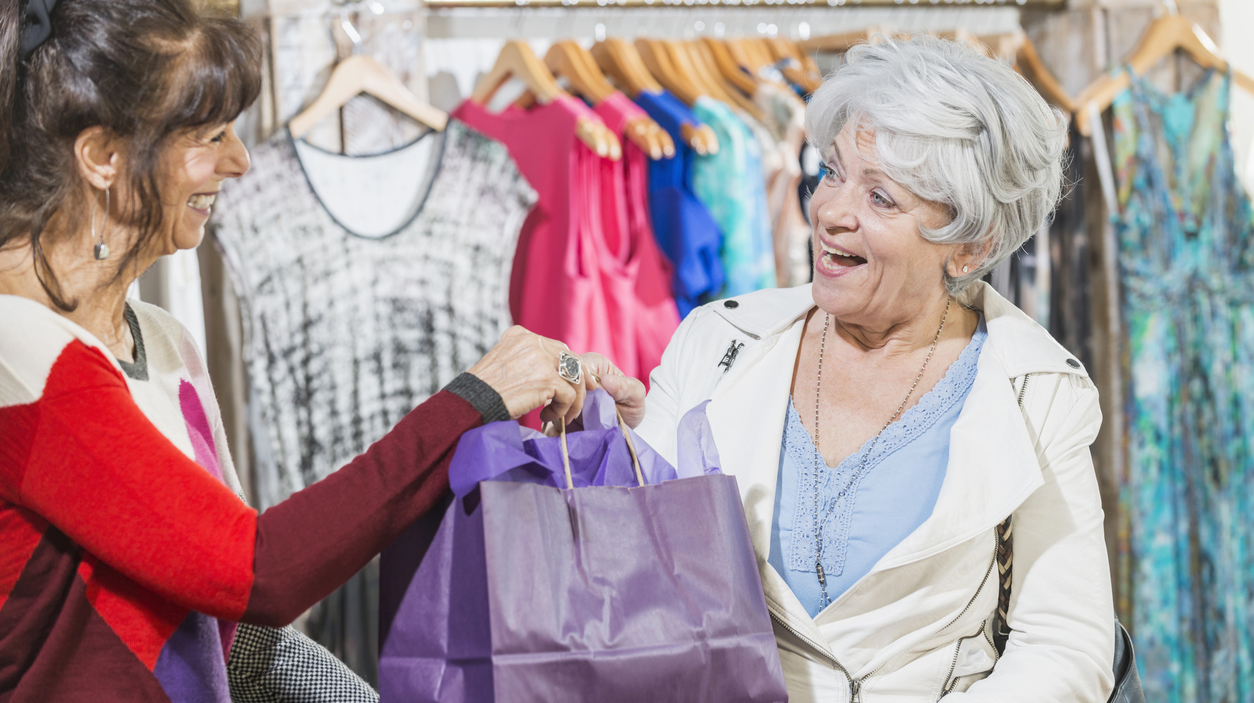 Sales assistant helping customer in clothing store