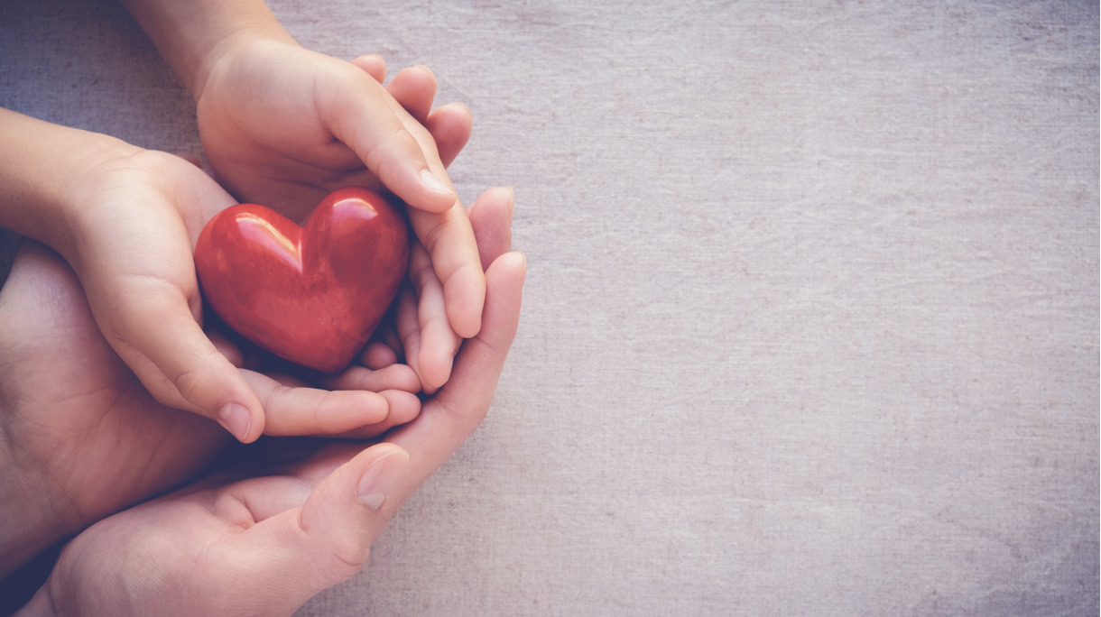 adult-and-child-hands-holding-red-heart-health-care-love-and-family-picture-id802252956