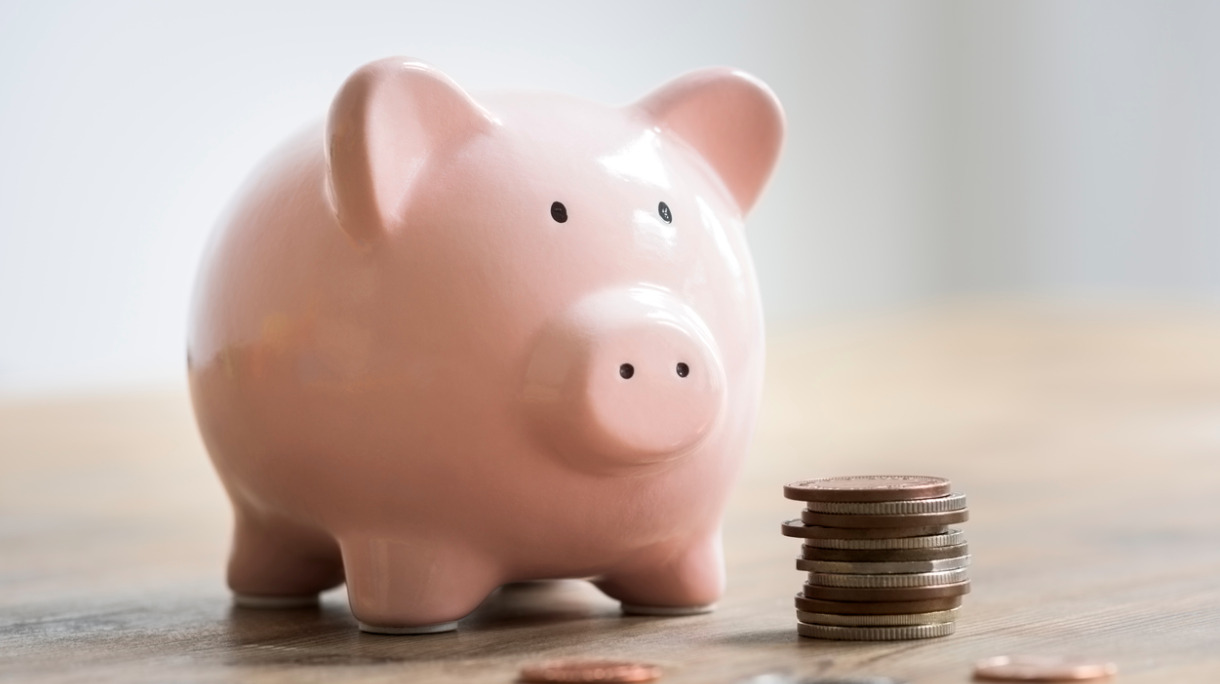 coins-beside-a-pink-piggy-bank-to-deposit-and-save-picture-id576924624
