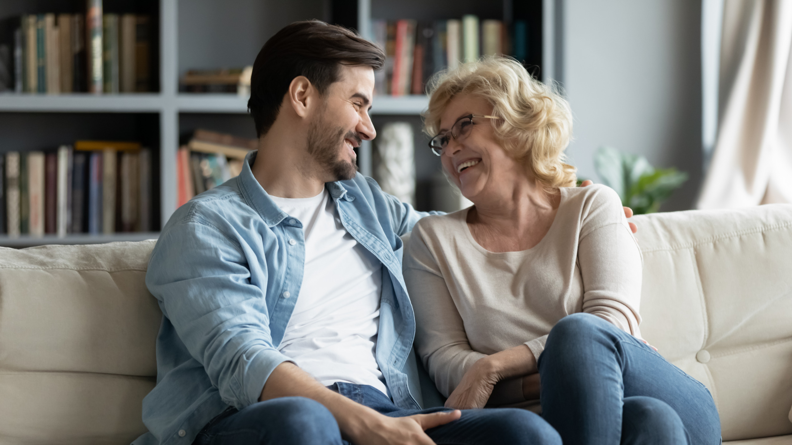 Overjoyed mature mother and adult son have fun at home