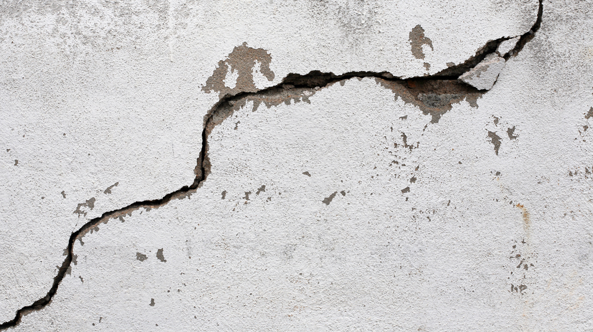 A big crack on an old, rotten wall